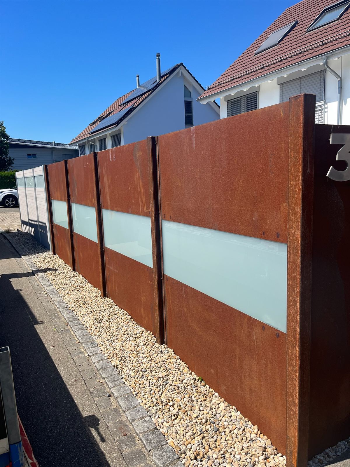 Sichtschutzwand aus Cortenstahl mit satiniertem Glasband